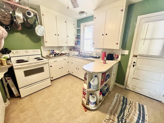 kitchen with white electric stove, open shelves, light countertops, white cabinets, and a sink