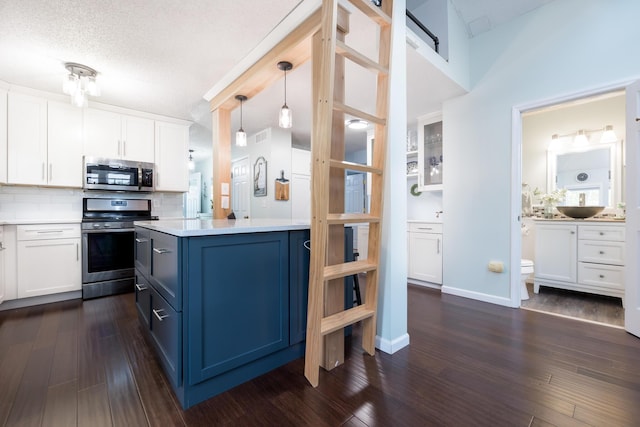11177 Sassafrass Rd, Lakeview, OH 43331 - kitchen featuring stainless steel appliances, light countertops, white cabinets, decorative backsplash, and a textured ceiling