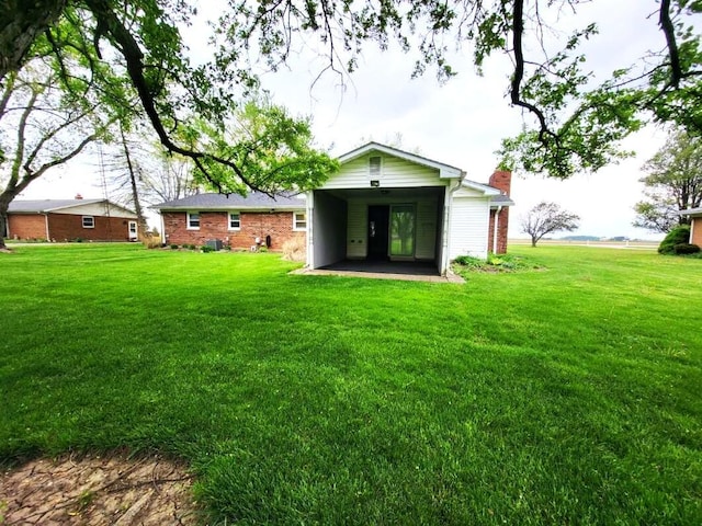 2169 State Route 49, Arcanum, OH 45304 - rear view of house with brick siding, a yard, and a chimney