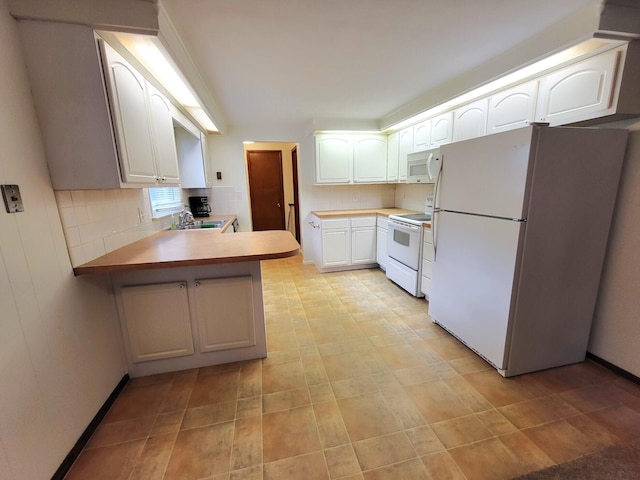 2169 State Route 49, Arcanum, OH 45304 - kitchen with a peninsula, white appliances, white cabinetry, tasteful backsplash, and a sink
