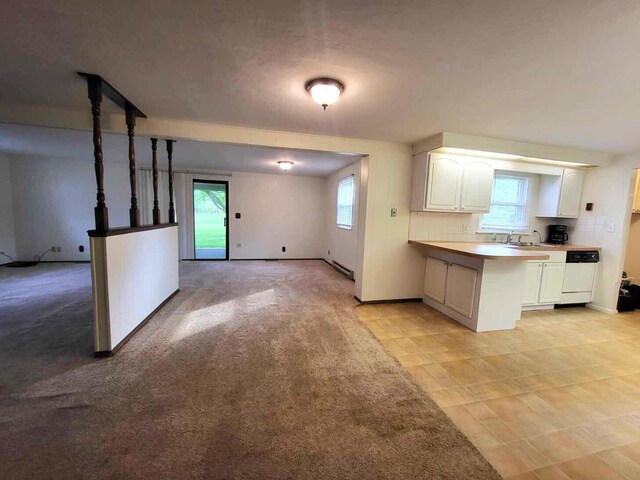 2169 State Route 49, Arcanum, OH 45304 - kitchen with white cabinets, white dishwasher, light countertops, a peninsula, and baseboards