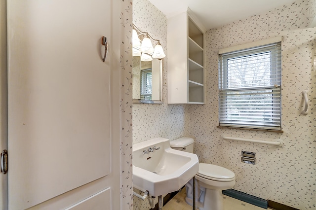 bathroom with baseboard heating, toilet, and sink