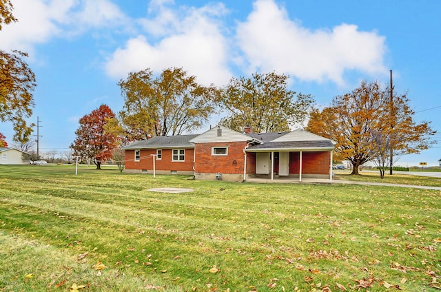 view of front of property featuring a front lawn and a patio