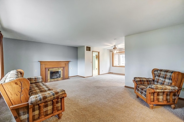 living area with a brick fireplace, light carpet, and ceiling fan