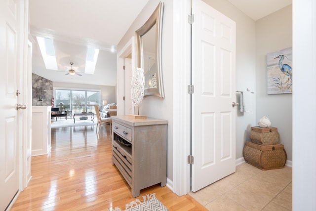 hallway featuring light hardwood / wood-style flooring and a skylight