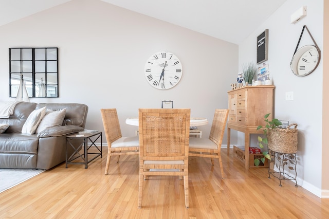 dining space featuring vaulted ceiling and light hardwood / wood-style flooring