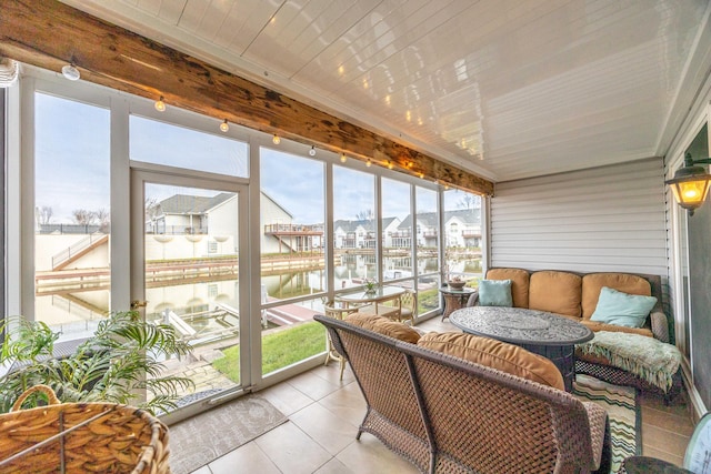 sunroom / solarium featuring a water view