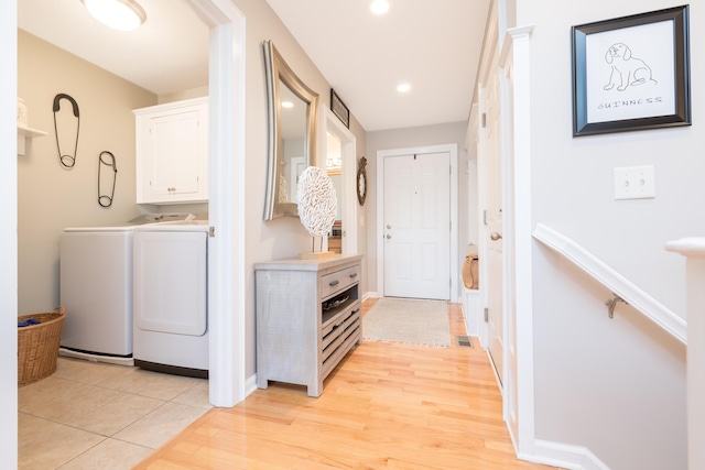 washroom featuring cabinets, washer and dryer, and light wood-type flooring