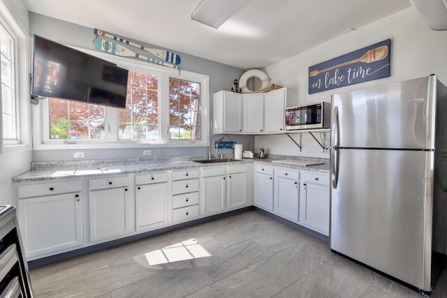 kitchen featuring range hood, sink, stainless steel appliances, and white cabinets