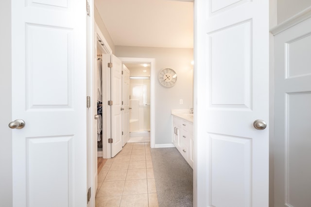 bathroom with tile patterned flooring, vanity, and walk in shower