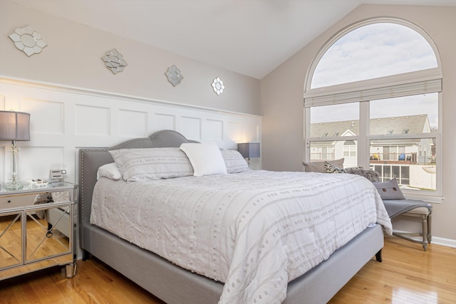 bedroom with lofted ceiling and light hardwood / wood-style floors