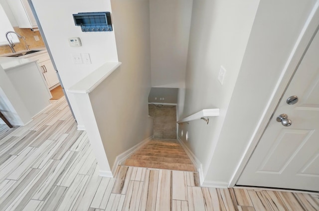 staircase featuring baseboards and wood finished floors