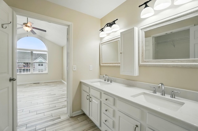 full bathroom with a sink, a ceiling fan, wood finished floors, and vaulted ceiling