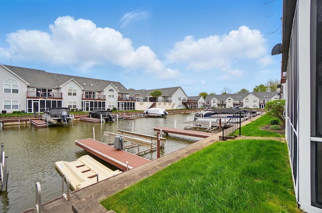 view of dock with a residential view, a water view, and a lawn