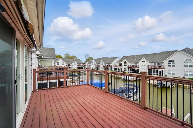 wooden deck featuring a water view and a residential view