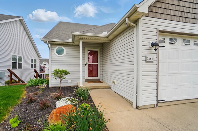 doorway to property featuring a garage and a shingled roof