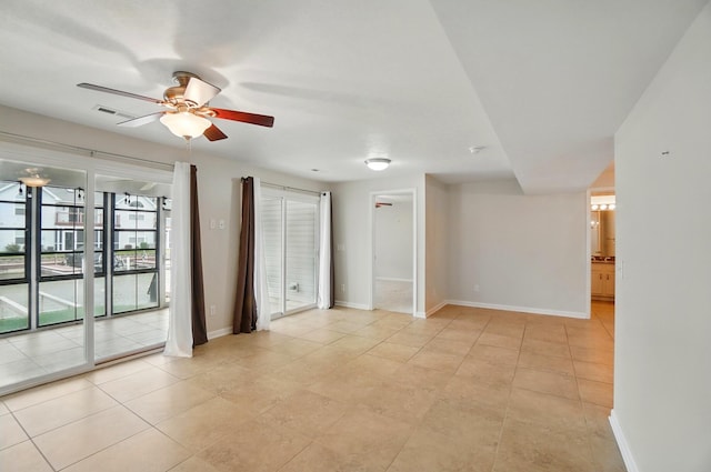 unfurnished room with baseboards, a ceiling fan, and light tile patterned flooring