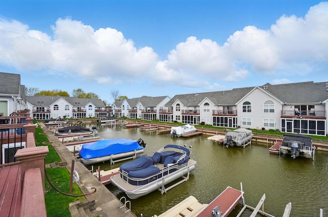 dock area with boat lift, a water view, and a residential view