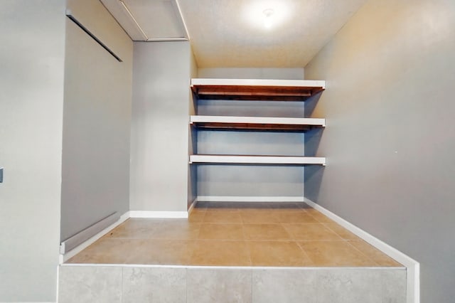 walk in closet with tile patterned flooring