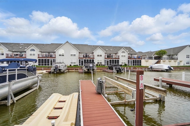 dock area with boat lift, a water view, and a residential view
