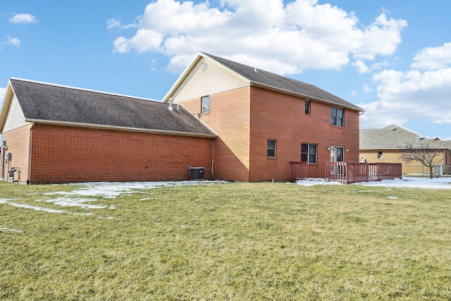 rear view of property featuring cooling unit, a lawn, and a deck