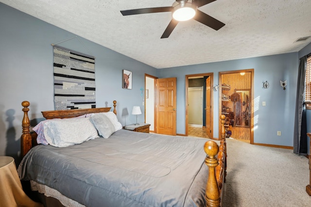 carpeted bedroom with ceiling fan and a textured ceiling