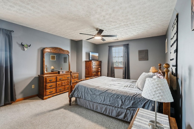 carpeted bedroom with ceiling fan and a textured ceiling