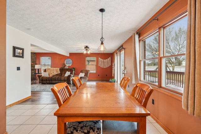 dining space with light tile patterned floors, a textured ceiling, and ceiling fan