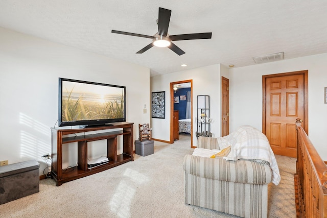 living room with ceiling fan, light colored carpet, and a textured ceiling