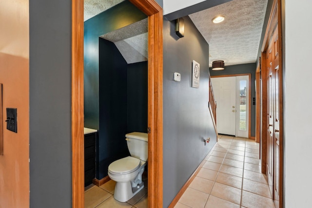 bathroom featuring tile patterned floors, a textured ceiling, and toilet