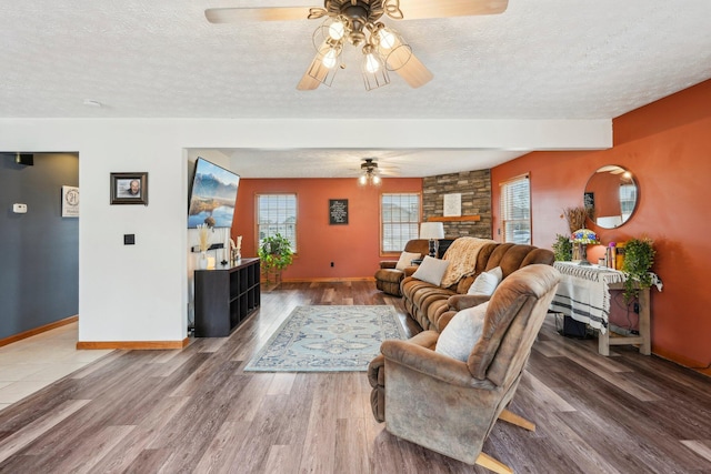 living room with ceiling fan, wood-type flooring, and a textured ceiling