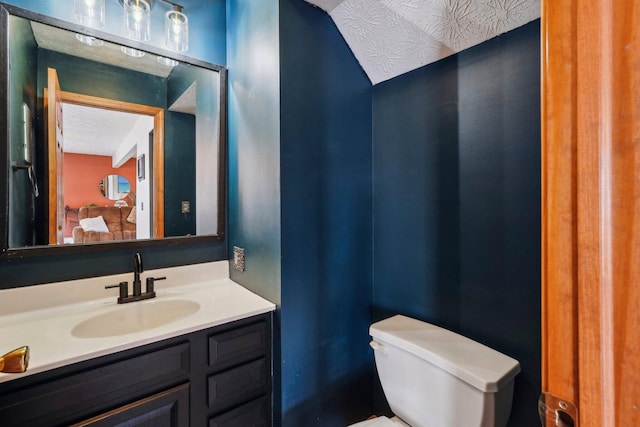 bathroom featuring vanity, toilet, and a textured ceiling