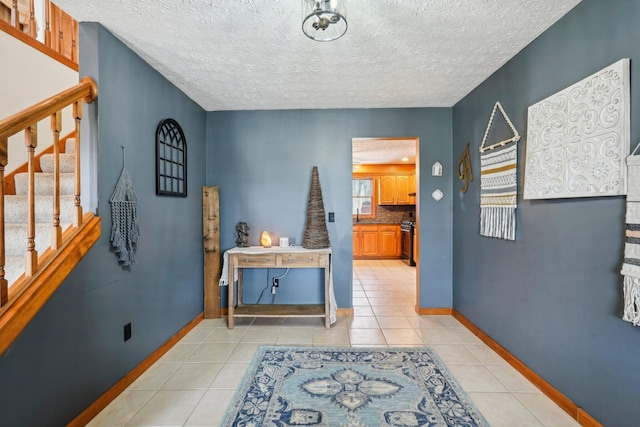 hallway featuring a textured ceiling and light tile patterned floors