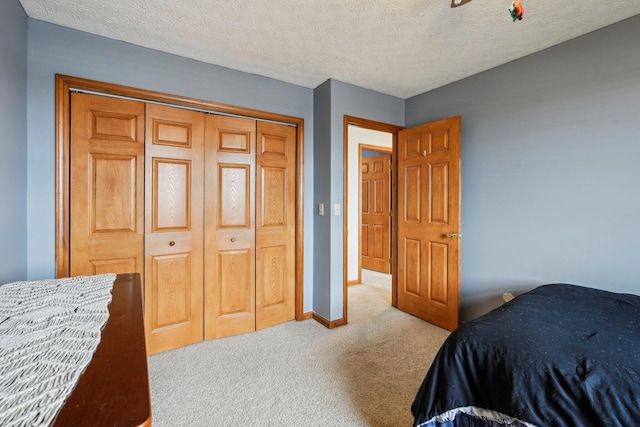 carpeted bedroom featuring a textured ceiling and a closet