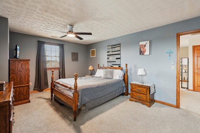 bedroom featuring ceiling fan, light colored carpet, and a textured ceiling