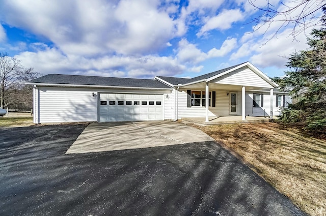 ranch-style house with a garage, concrete driveway, and covered porch