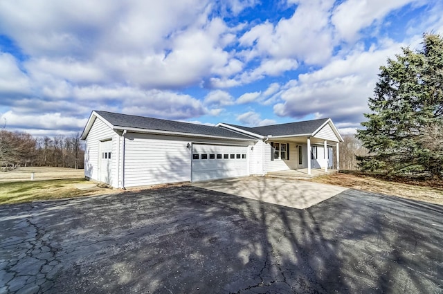 single story home with aphalt driveway, a porch, and a garage