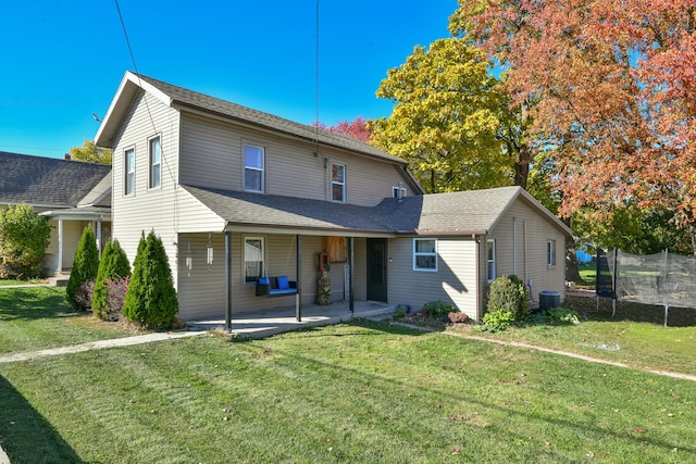 back of house with a patio, a yard, central AC, and a trampoline