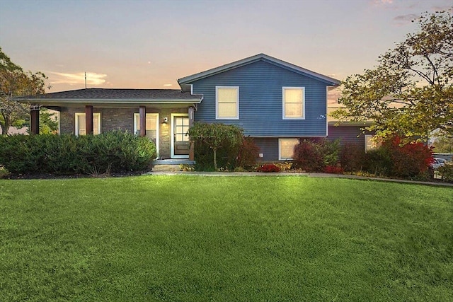 tri-level home featuring a lawn and brick siding