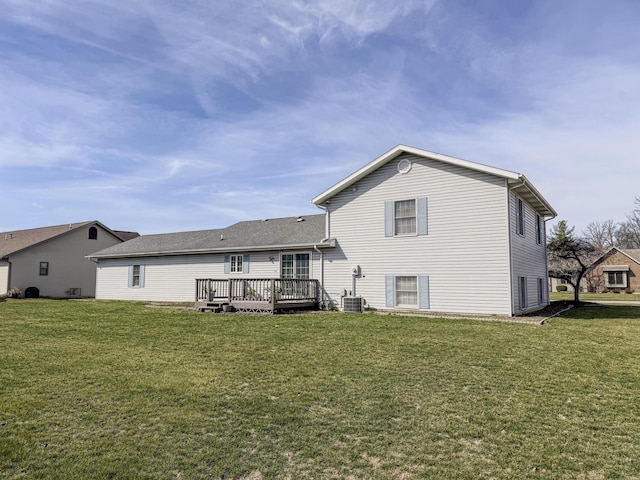 back of house with a deck and a lawn
