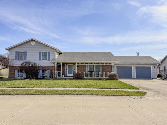 tri-level home featuring driveway, a front yard, an attached garage, and brick siding