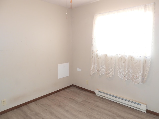 421 Summit St, Sidney, OH 45365 - spare room with a baseboard heating unit, light wood-style flooring, and baseboards