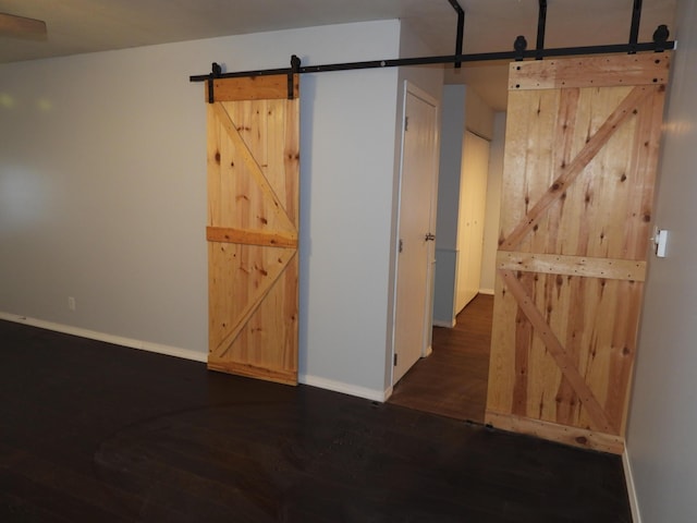 421 Summit St, Sidney, OH 45365 - spare room featuring a barn door, baseboards, and wood finished floors