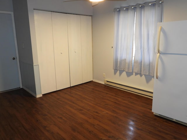 421 Summit St, Sidney, OH 45365 - unfurnished bedroom featuring a closet, baseboard heating, dark wood-style flooring, and freestanding refrigerator