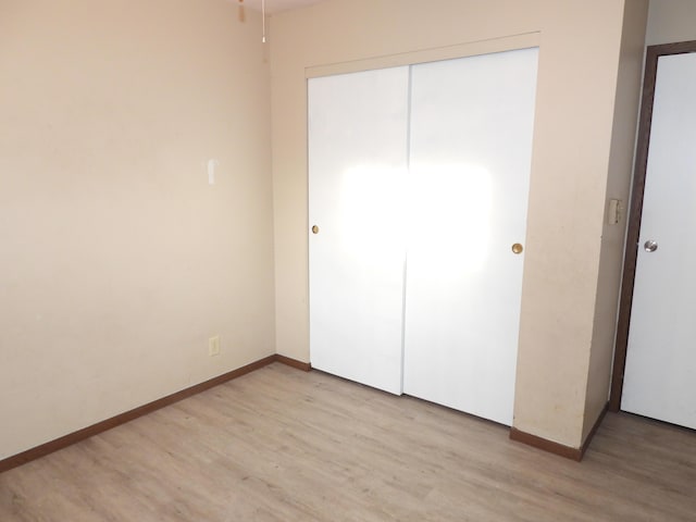 421 Summit St, Sidney, OH 45365 - unfurnished bedroom with light wood finished floors, baseboards, and a closet
