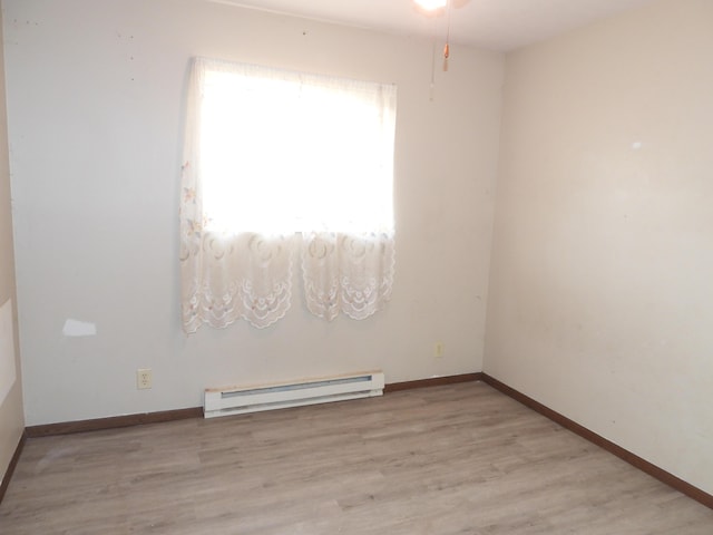 421 Summit St, Sidney, OH 45365 - spare room with a baseboard radiator, baseboards, wood finished floors, and a ceiling fan