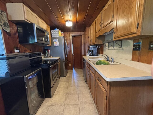 9029 Maple St, Huntsville, OH 43324 - kitchen with appliances with stainless steel finishes, wooden ceiling, light countertops, light tile patterned flooring, and brown cabinets