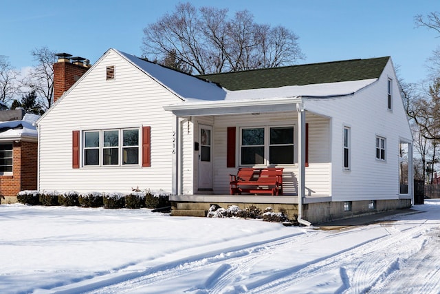 bungalow-style home featuring covered porch and a chimney