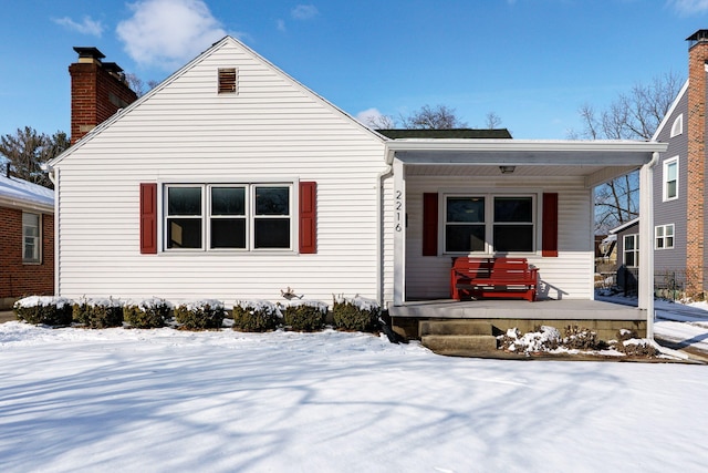 bungalow-style home with a chimney and a porch