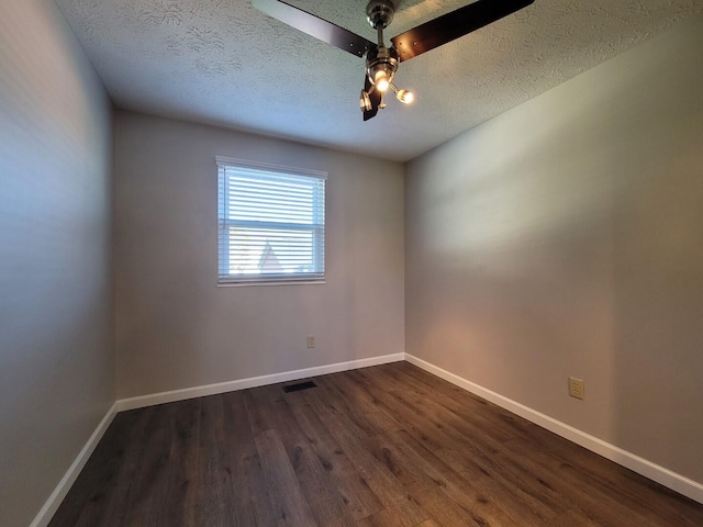 empty room with dark wood-style floors, baseboards, visible vents, and a textured ceiling